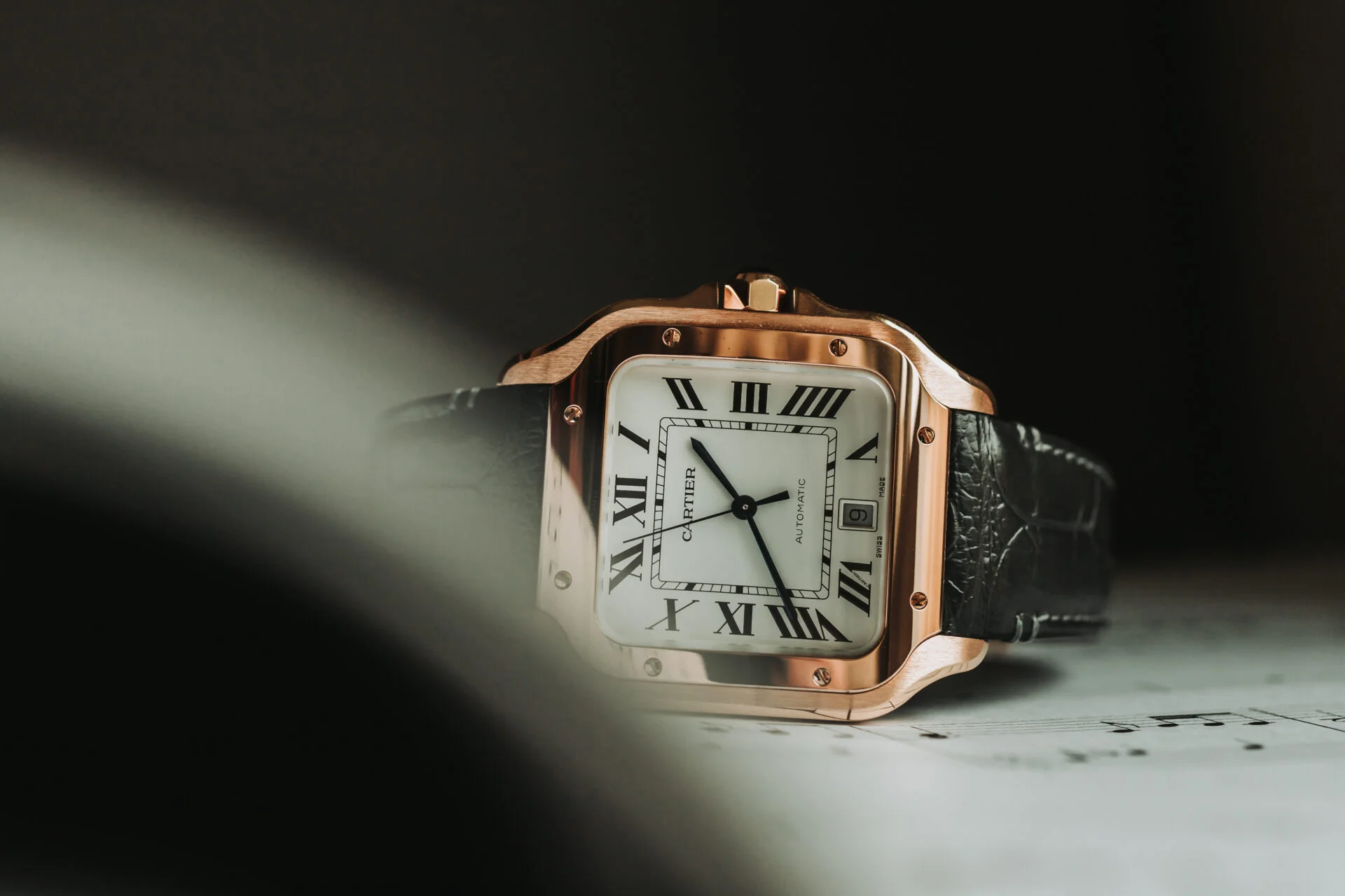 Cartier Santos Rose Gold Watch on Sheet Music Book